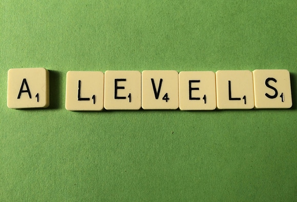 Scrabble tiles spelling "A LEVELS" on a green background, indicating a focus on academic qualifications in the UK.