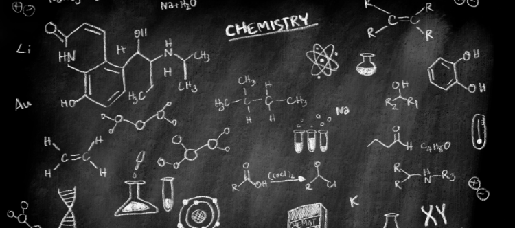 Chalkboard filled with various chemistry symbols, formulas, molecular structures, and the word "Chemistry" prominently displayed at the top.